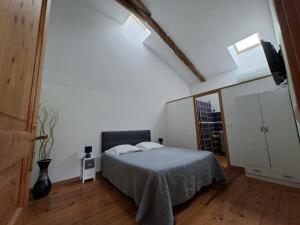 a white bedroom with a bed and a mirror at La Mirabelle in Montazeau