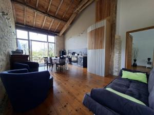 a living room with a couch and a dining room at La Mirabelle in Montazeau