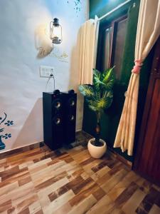 a room with a speaker and a potted plant at Prathvi Cottages-04 in Lucknow