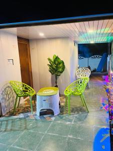 a patio with two chairs and a table and a plant at Prathvi Cottages-04 in Lucknow