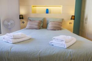 a bed with two folded towels on top of it at Apt le Nid in Tourrettes-sur-Loup