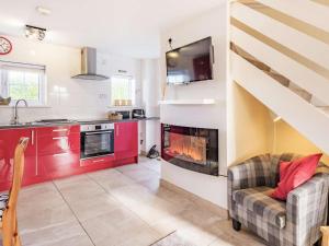 a kitchen and a living room with a fireplace at 2 Bed in Bude oc-86920 in Kilkhampton
