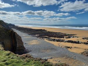 a beach with a rocky shore and the ocean at 2 Bed in Bude oc-86920 in Kilkhampton +13 photos