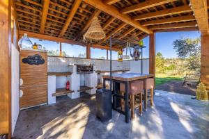 an outdoor kitchen with a table and a stove at Casinha Revira Volta in Nesperal