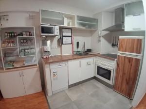 a kitchen with white cabinets and white appliances at MERINDADES AMAZUL MILANO - Piso turístico - Medina de Pomar in Medina de Pomar