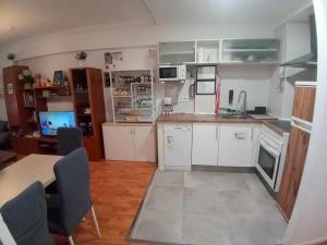 a kitchen with white cabinets and a table and chairs at MERINDADES AMAZUL MILANO - Piso turístico - Medina de Pomar in Medina de Pomar