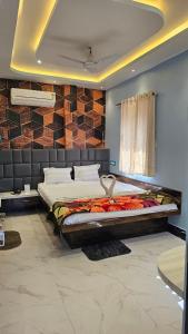 a bedroom with a large bed in front of a brick wall at Balaji Hotel and Resturant in Kolaghat +6 photos
