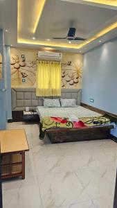 a room with a bed and a wall with at Balaji Hotel and Resturant in Kolaghat