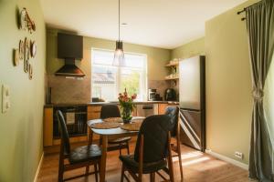 a kitchen with a table and chairs in a kitchen at Frafjord Apartments Frøya in Dirdal