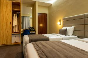 a hotel room with two beds and a closet at Kululwa House in Luanda +25 photos