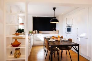 a kitchen with a dining table and a kitchen with white cabinets at Apt le Nid in Tourrettes-sur-Loup