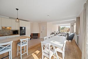 a kitchen and living room with a white table and chairs at Summer Dream in De Haan