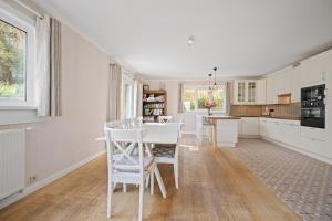 a white kitchen with a table and chairs at Summer Dream in De Haan