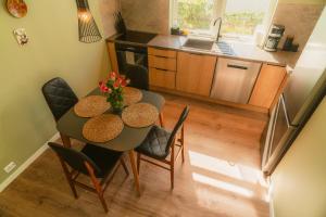 a kitchen and dining room table with chairs and a kitchen at Frafjord Apartments Frøya in Dirdal +9 photos