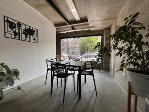 a dining room with a table and chairs and a plant at DOCTA Residencia in Córdoba