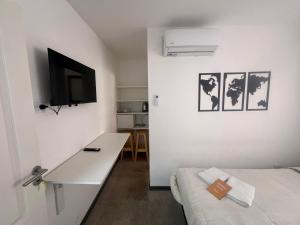 a room with a bed and a desk and a tv at DOCTA Residencia in Córdoba