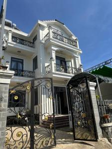 a white house with a gate in front of it at Carol Dalat in Khu Chi Lăng