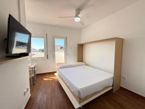 a bedroom with a bed and a flat screen tv at Agi Josep Sabater in Roses