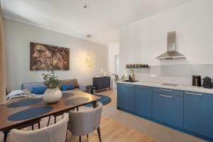 a kitchen and dining room with blue cabinets and a table at dreamfactory Residence - Royal Westside in Vienna