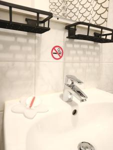 ein Waschbecken mit Wasserhahn und einem „Rauchen verboten“-Schild in der Unterkunft MonAppart in Gera + 25 Fotos