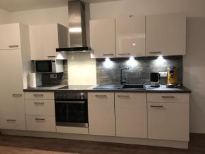 a kitchen with white cabinets and a sink at Seeterrasse in Allensbach