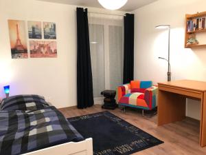 a bedroom with a bed and a desk and a chair at Seeterrasse in Allensbach