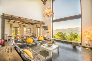 a living room with a couch and a large window at Espectacular casa rural en el corazón del Baztán in Ziga