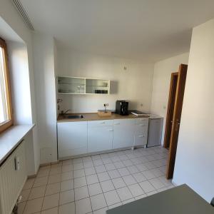 a kitchen with white cabinets and a sink at Moderne 2 Zimmer Appartement in Straubing