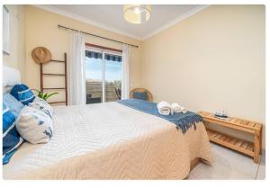 a bedroom with a large bed with two towels on it at Sunny apartamento in Portimão +31 photos