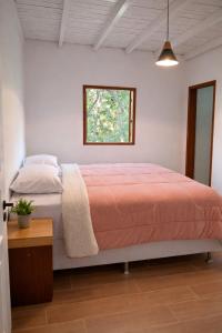 a bedroom with a bed and a window at Chalé Pedra Furada in Resende