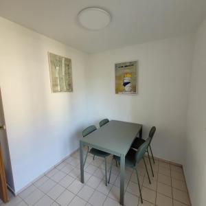 a table and chairs in a room with white walls at Moderne 2 Zimmer Appartement in Straubing