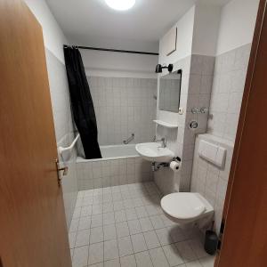 a bathroom with a toilet and a sink and a tub at Moderne 2 Zimmer Appartement in Straubing