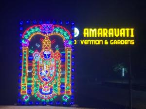 a building covered in christmas lights next to a sign at Amaravathi Convention & Function hall in Penuganchiprolu