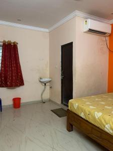 a bedroom with a bed and a sink and a window at Amaravathi Convention & Function hall in Penuganchiprolu