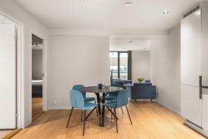 a dining room with a table and blue chairs at Prime Location - 2 Bedroom Apartment! in Bergen