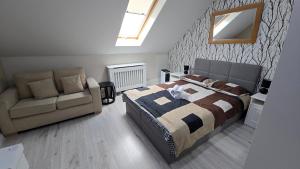 a bedroom with a bed and a couch and a mirror at Zacisze in Sokółka +26 photos