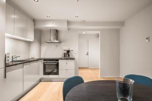 a kitchen with white cabinets and a table with blue chairs at Prime Location - 2 Bedroom Apartment! in Bergen +13 photos