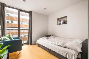 a bedroom with a bed and a couch and a window at Prime Location - 2 Bedroom Apartment! in Bergen
