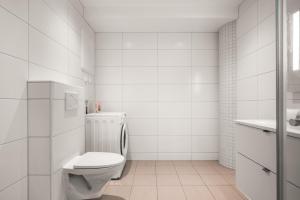 a white bathroom with a toilet and a sink at Prime Location - 2 Bedroom Apartment! in Bergen