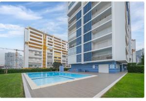 a large building with a swimming pool in front of it at Sunny apartamento in Portimão
