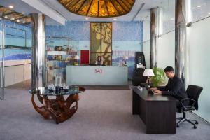 a man sitting at a desk in an office at Hotel Saj Luciya in Trivandrum