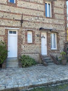 a brick building with two white doors on it at Neuville secrete in Dieppe
