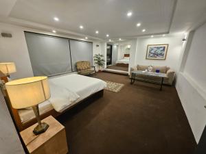 a large bedroom with a bed and a couch at 12th Avenue in Lahore