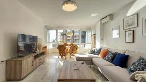 a living room with a couch and a tv and a table at Sunset Torrox Costa in Torrox +19 photos