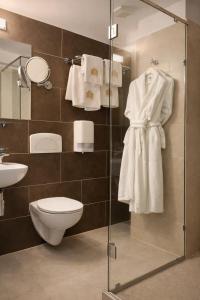a bathroom with a shower with a toilet and towels at Hotel Paradis in Cluj-Napoca +29 photos