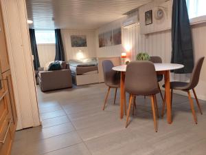 a living room with a table and chairs and a bedroom at Ved sjøen i syd in Svenevik