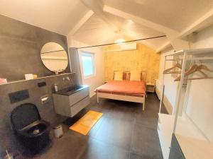 a bedroom with a bed and a bathroom with a mirror at B&B Basseterre in Basse
