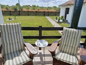 two chairs and a table on a deck with a yard at Veseli svet-Zvizdar,Ub in Ub