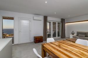 a living room with a dining room table and a bedroom at Endless Blue Anesea House in Provatas