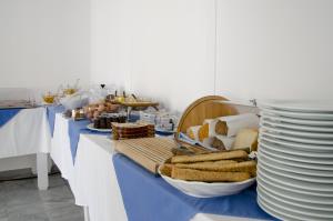 a buffet with a blue table with plates and bread at RK Beach Hotel in Kamari